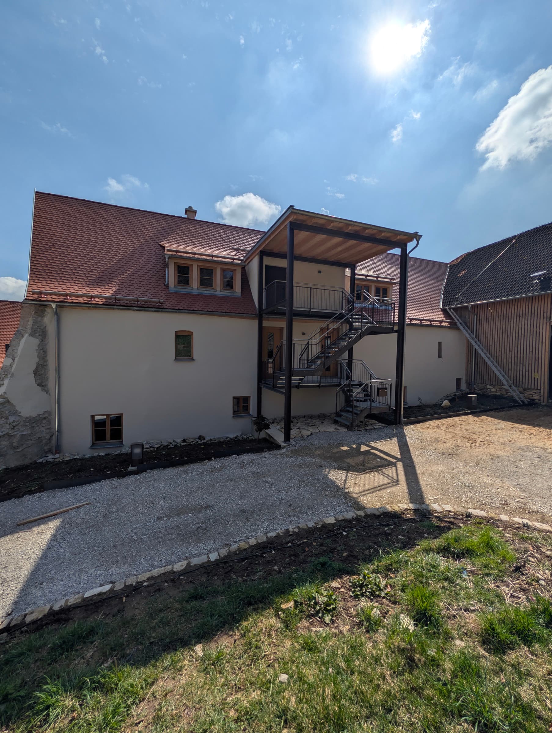 Rückansicht des sanierten Bauernhauses am Hofberg mit Terrassen-Zugang zur Ferienwohnung