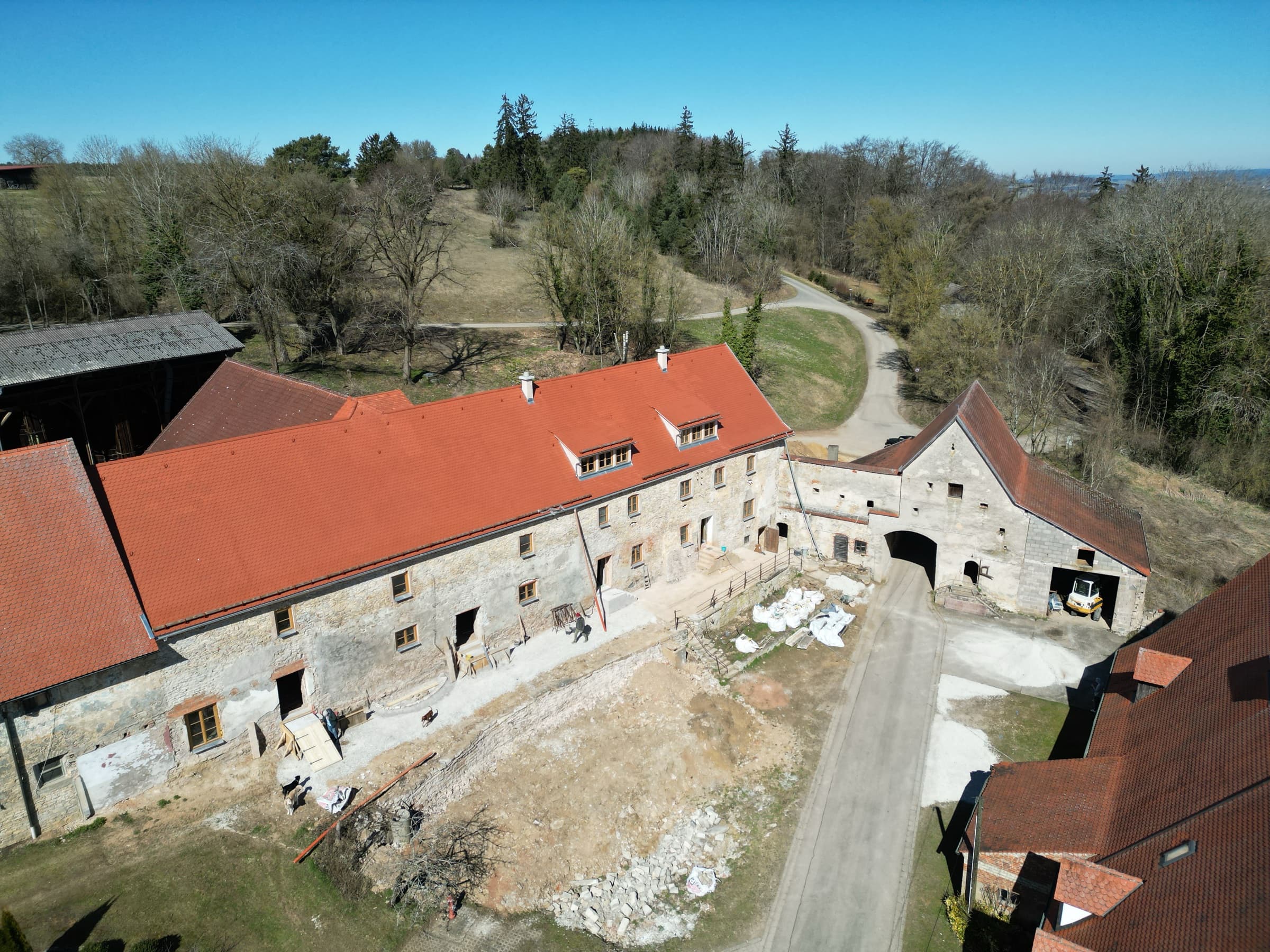 Luftaufnahme Hofberg 1 — links das sanierte Wohnstallhaus, rechts das noch unsanierte Torhaus von 1490 mit historischem Bruchsteinmauerwerk