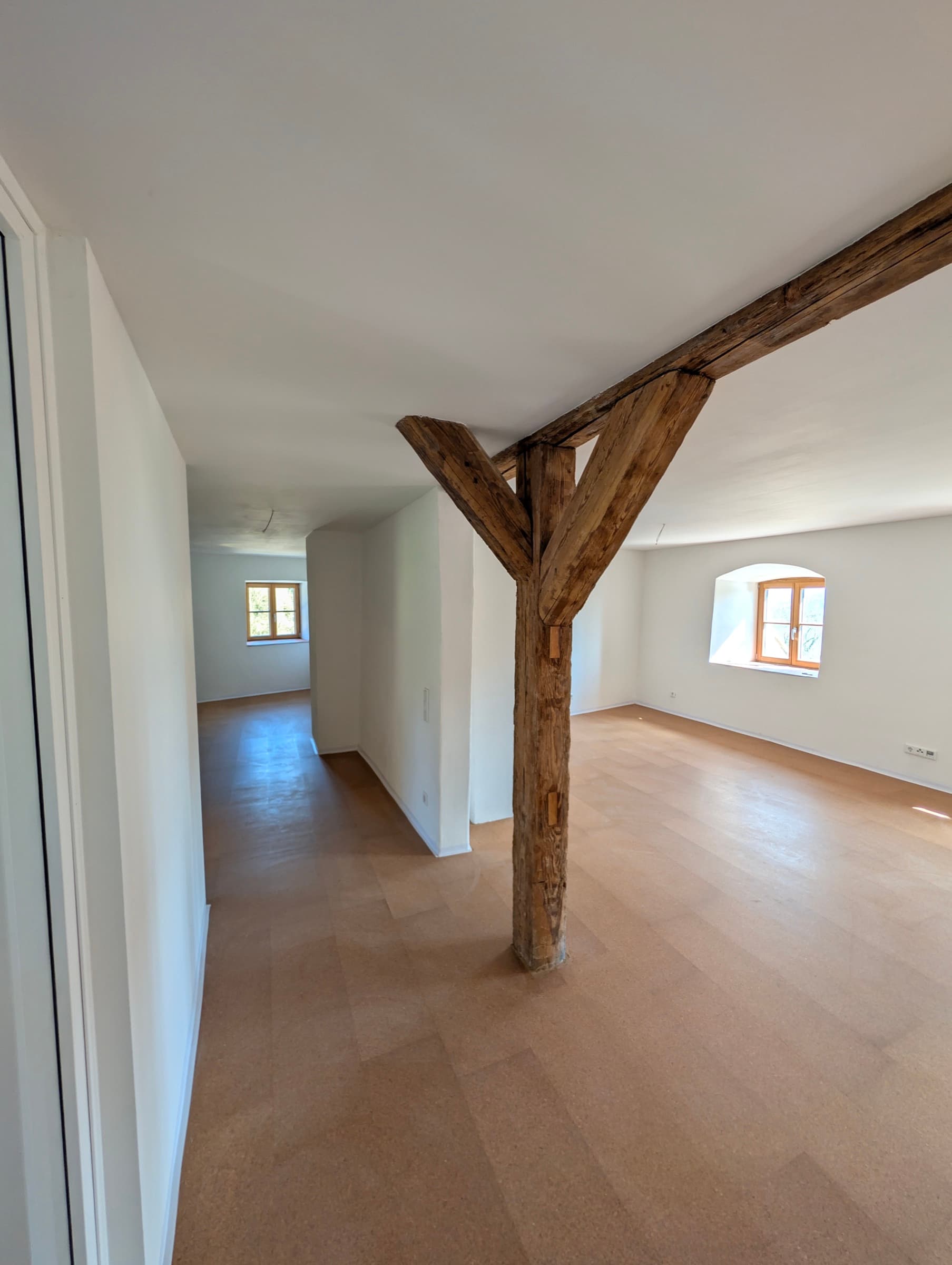 Sanierter Innenraum des Bauernhauses mit sichtbarem historischen Eichensparren